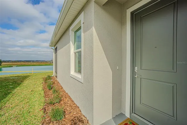 a view of a house with a yard and potted plants