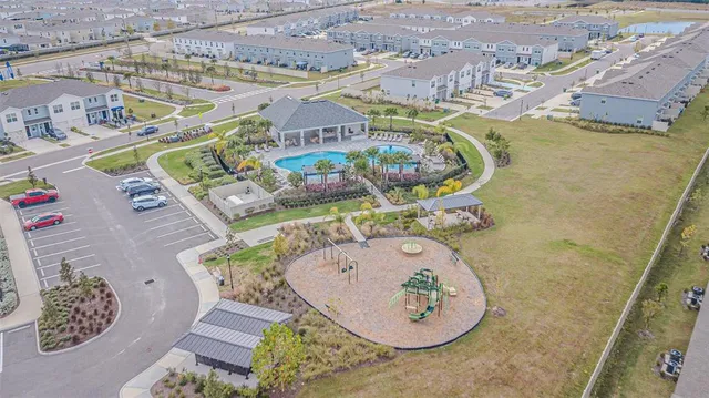 an aerial view of a swimming pool with outdoor seating