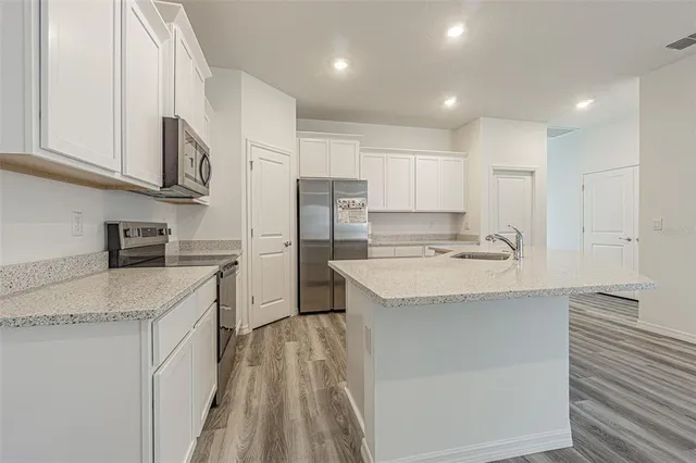 a kitchen with kitchen island a sink stainless steel appliances and cabinets