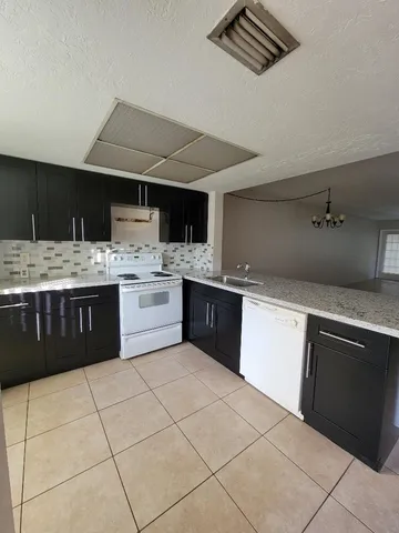 a kitchen with a stove sink and cabinets