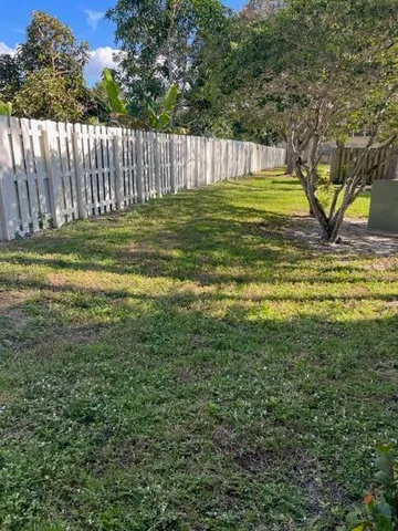 a view of a golf ground with a large trees