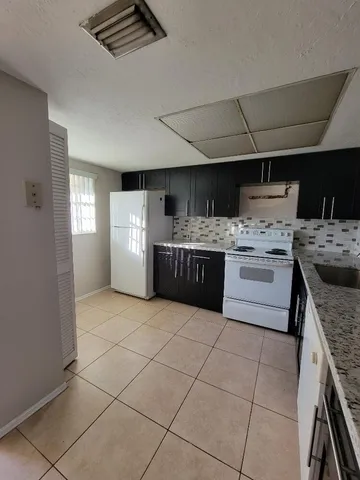 a kitchen with stainless steel appliances granite countertop a stove a sink dishwasher and a refrigerator