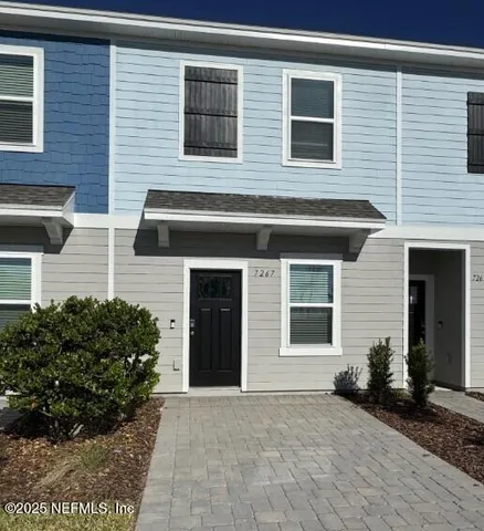 a view of a house with a yard and potted plants