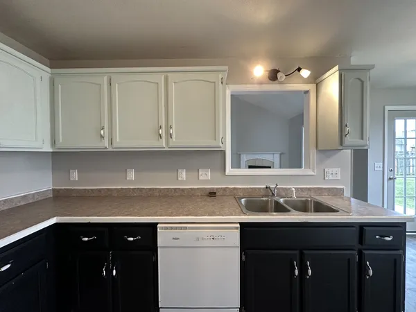a sink with granite countertop white cabinets and a sink
