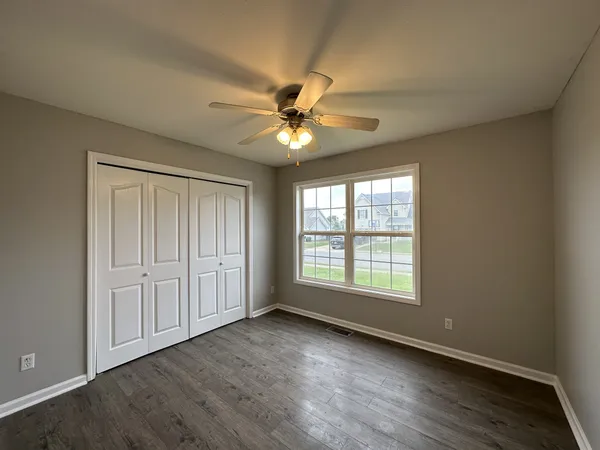 a view of an empty room with a window and a fan