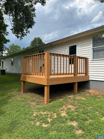 a view of a white house in front of a yard with potted plants