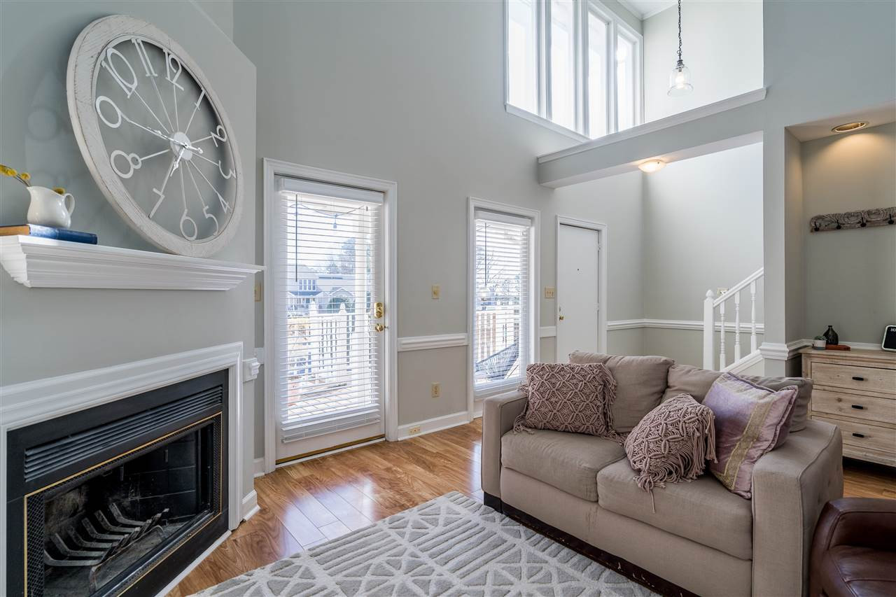 7010 Sandy Forks Road, Unit 207 Raleigh, NC 27609 - Photo 6 of 27 Open living room features vaulted ceilings, recent laminate hardwoods, neutral paint, and a wood burning fireplace! Living Room