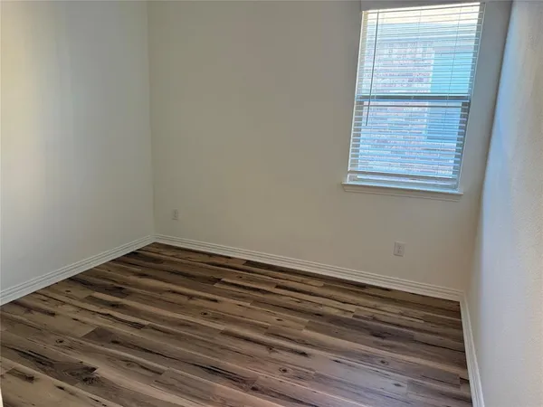 a view of a small space with wooden floor and a window