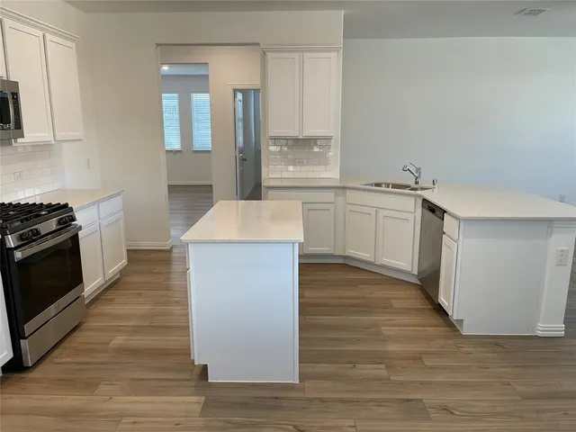 a kitchen with granite countertop white cabinets and white appliances