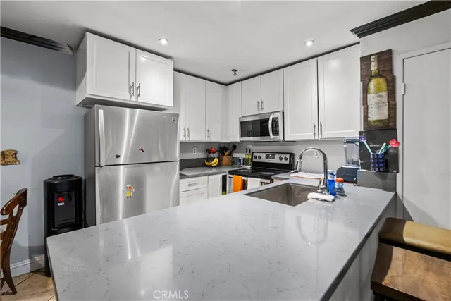 a kitchen with stainless steel appliances refrigerator stove microwave and sink