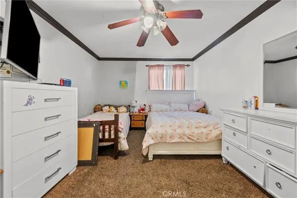 a bedroom with a bed and a flat tv screen on dresser