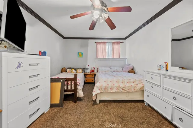 a bedroom with a bed and a flat tv screen on dresser