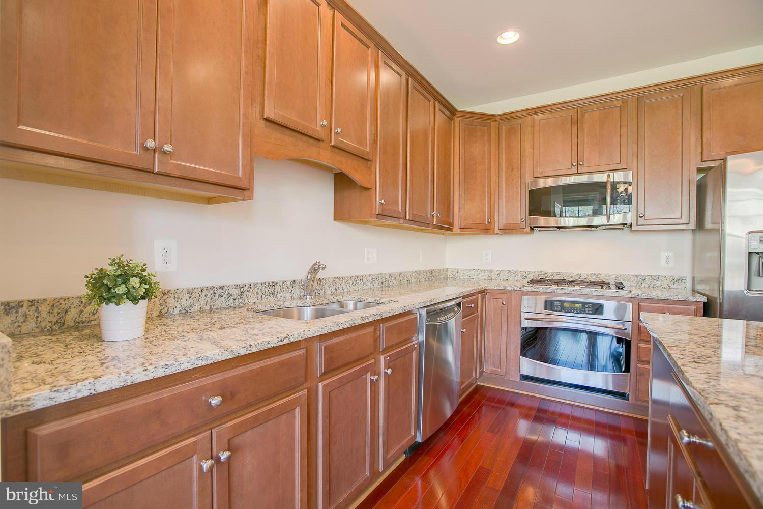 141 Short Branch Road Stafford, VA 22556 - Photo 11 of 30 a kitchen with granite countertop a stove a sink and a microwave