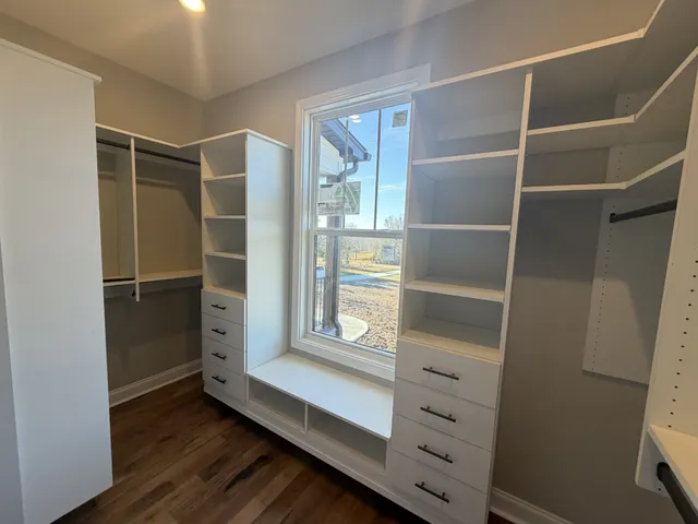 a view of walk in closet with empty racks
