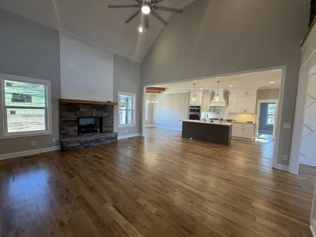 a view of a livingroom with furniture a fireplace wooden floor and fire place
