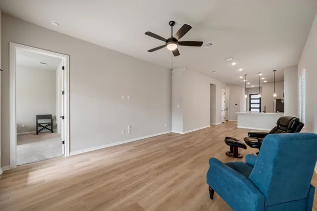 a living room with furniture and a view of kitchen