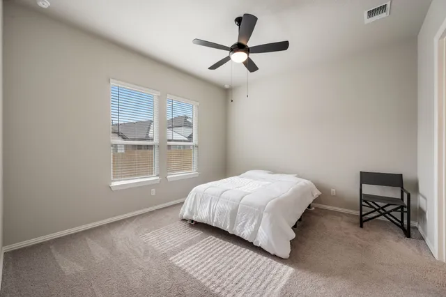 a bedroom with a bed a window and a chair