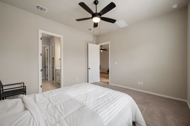 a bedroom with a large bed and a chandelier