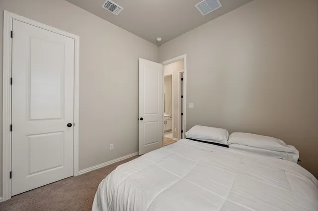 a bedroom with a large bed and a shower