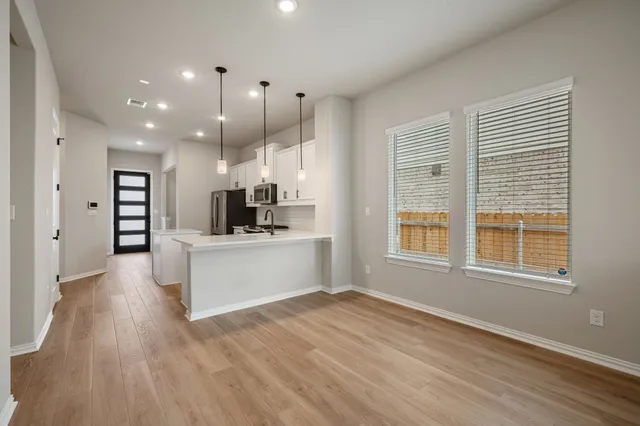 a view of kitchen with stainless steel appliances refrigerator oven and cabinets