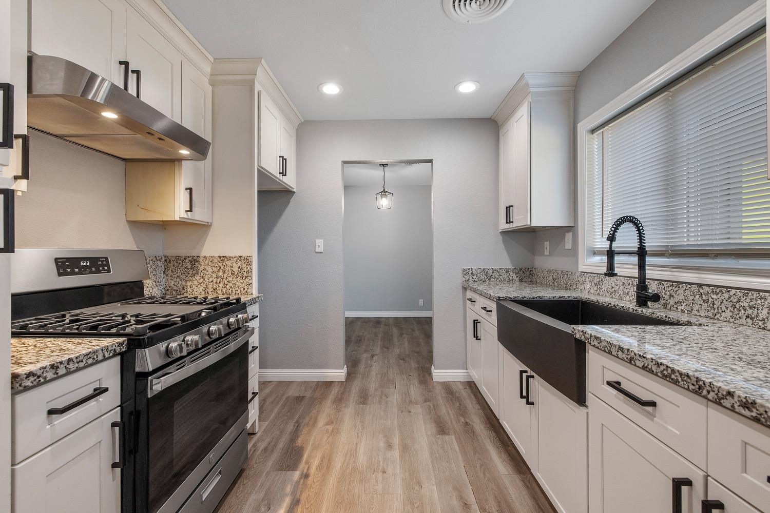 71 East Griffith Way Fresno, CA 93704 - Photo 15 of 35 a kitchen with granite countertop a sink stove and cabinets