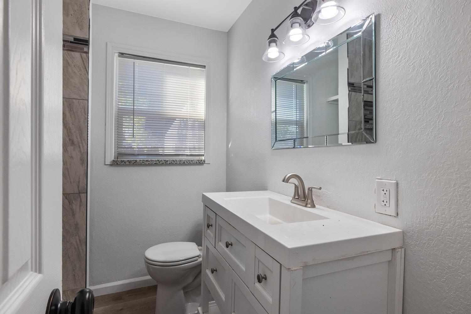 71 East Griffith Way Fresno, CA 93704 - Photo 23 of 35 a bathroom with a sink toilet and mirror