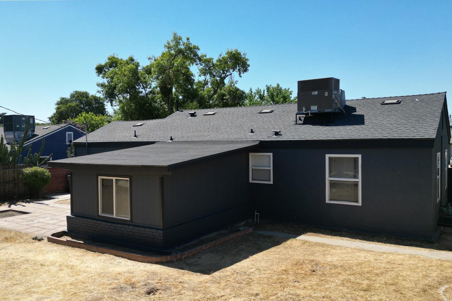 71 East Griffith Way Fresno, CA 93704 - Photo 26 of 35 a backyard of a house with wooden fence and large trees