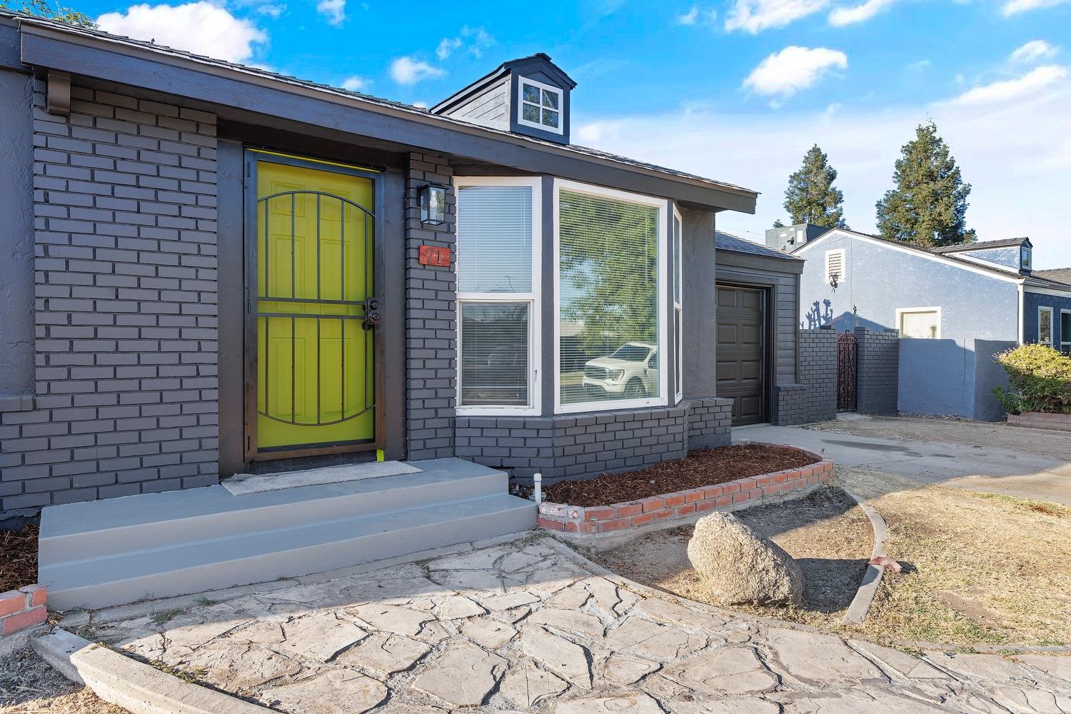 71 East Griffith Way Fresno, CA 93704 - Photo 4 of 35 a front view of a house with a yard