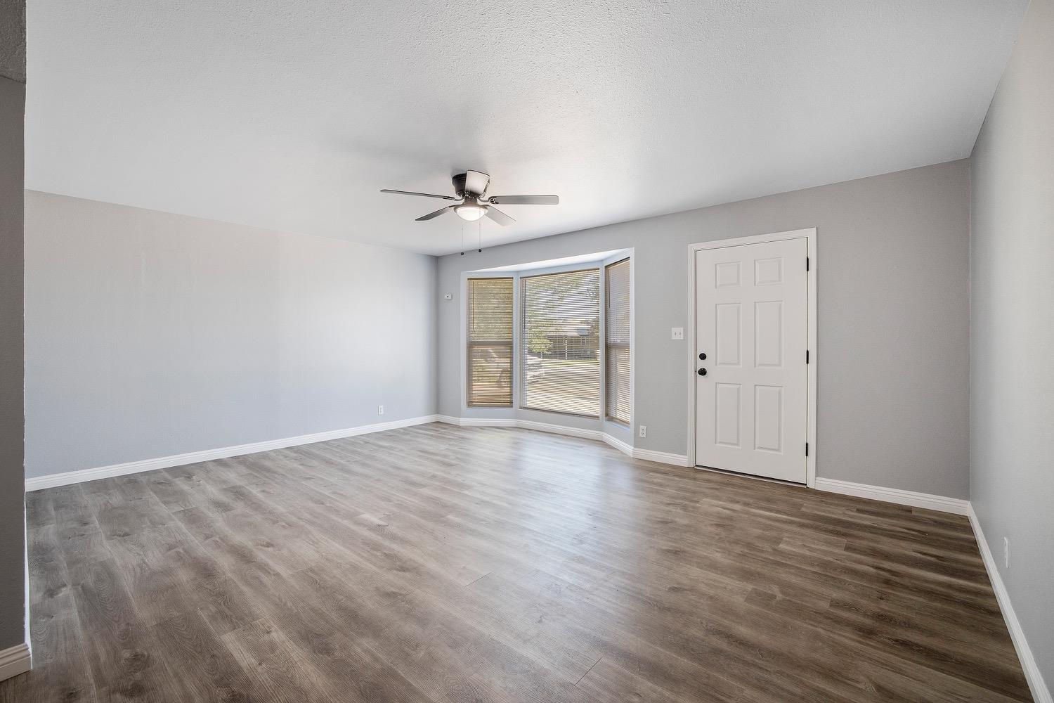 71 East Griffith Way Fresno, CA 93704 - Photo 7 of 35 a view of an empty room with wooden floor and a window