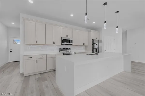 a kitchen with white cabinets and stainless steel appliances
