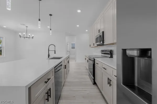 a kitchen with stainless steel appliances a sink and a refrigerator