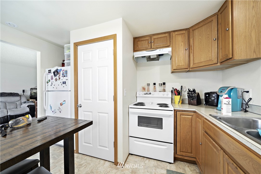 6028 Rockefeller Avenue Everett, WA 98203 - Photo 11 of 25 a kitchen with stainless steel appliances white cabinets and wooden floor