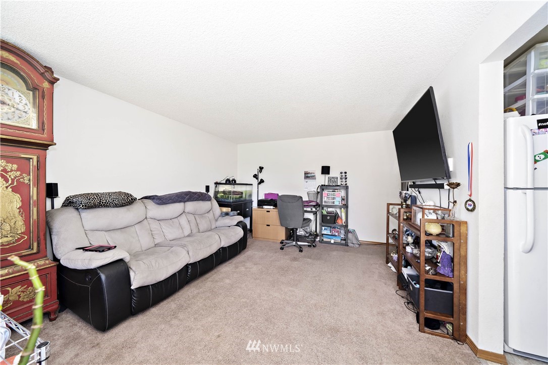 6028 Rockefeller Avenue Everett, WA 98203 - Photo 15 of 25 a living room with furniture a flat screen tv and gym equipment