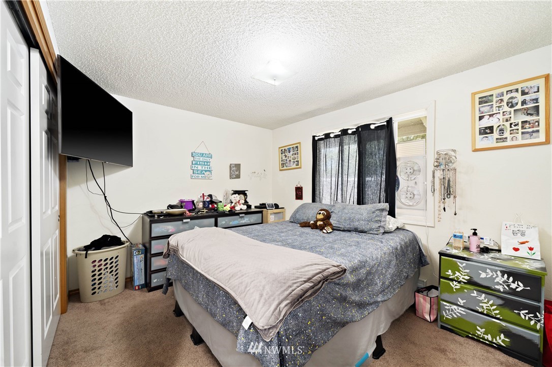 6028 Rockefeller Avenue Everett, WA 98203 - Photo 18 of 25 a bedroom with a bed and a flat screen tv
