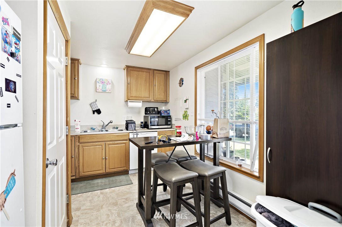 6028 Rockefeller Avenue Everett, WA 98203 - Photo 9 of 25 a kitchen with stainless steel appliances granite countertop table chairs sink and cabinets