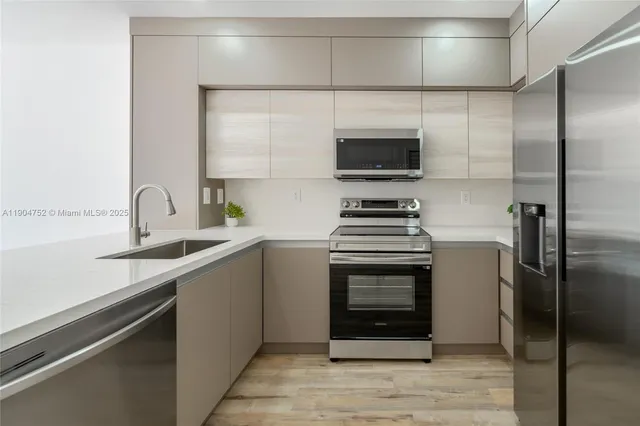 a kitchen with a sink and stainless steel appliances