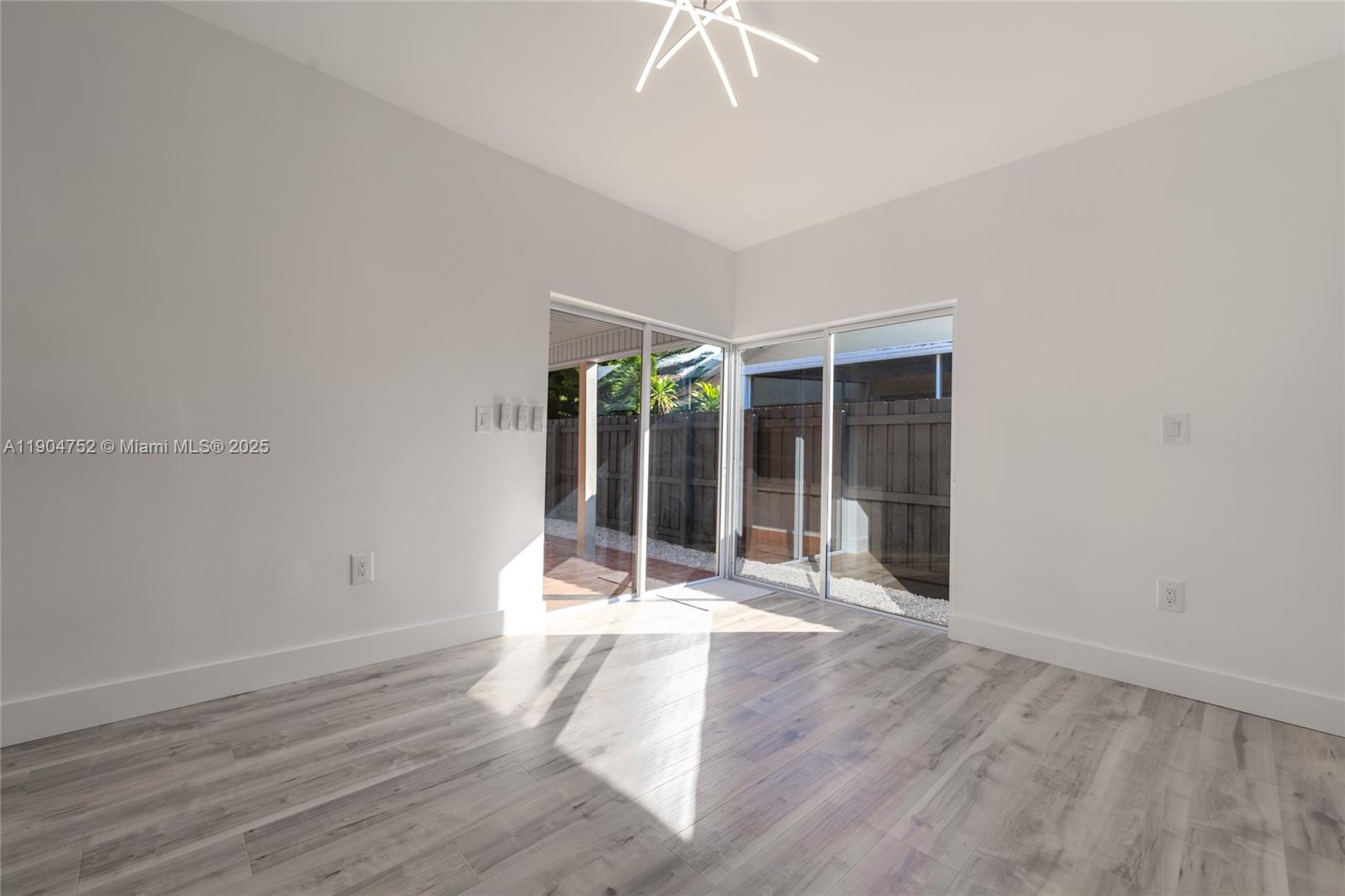 14231 Southwest 147th Place Miami, FL 33196 - Photo 16 of 35 a view of an empty room with wooden floor and a window