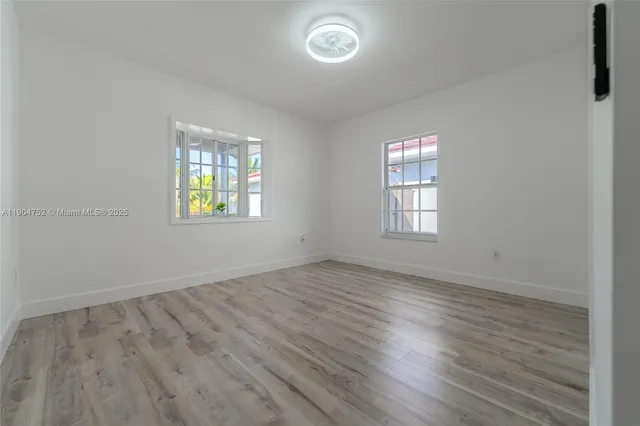 a view of a hallway with wooden floor and closet