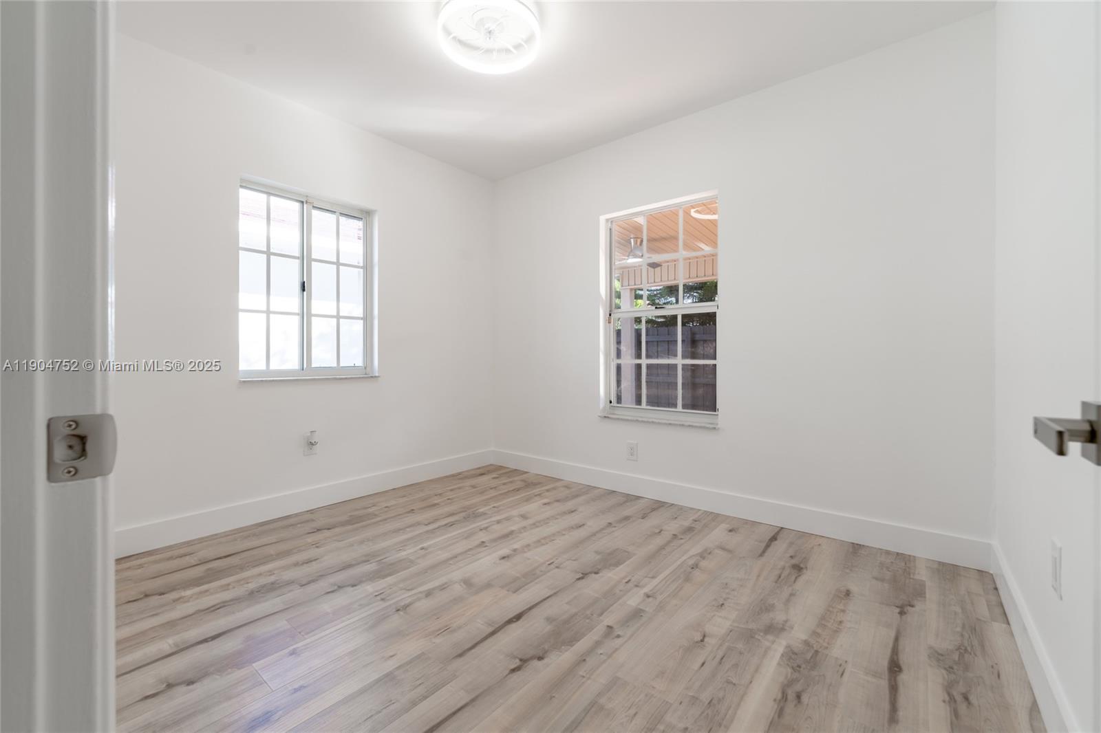 14231 Southwest 147th Place Miami, FL 33196 - Photo 24 of 35 an empty room with wooden floor and windows