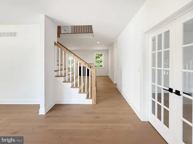 a view of staircase with lots of frames on wall and a window