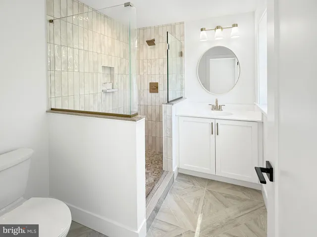 a bathroom with a toilet a sink and mirror