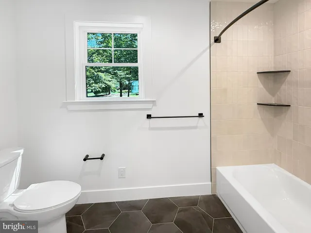 a bathroom with a toilet and a bathtub
