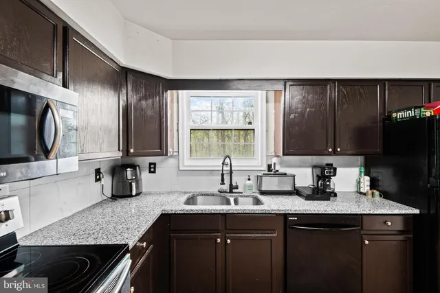 a kitchen with a sink stove top oven and microwave