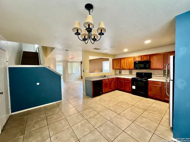 a kitchen with stainless steel appliances kitchen island granite countertop a refrigerator and a sink