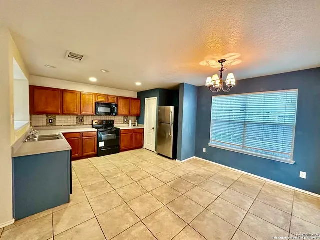 a large kitchen with stainless steel appliances granite countertop a stove a sink dishwasher and a refrigerator
