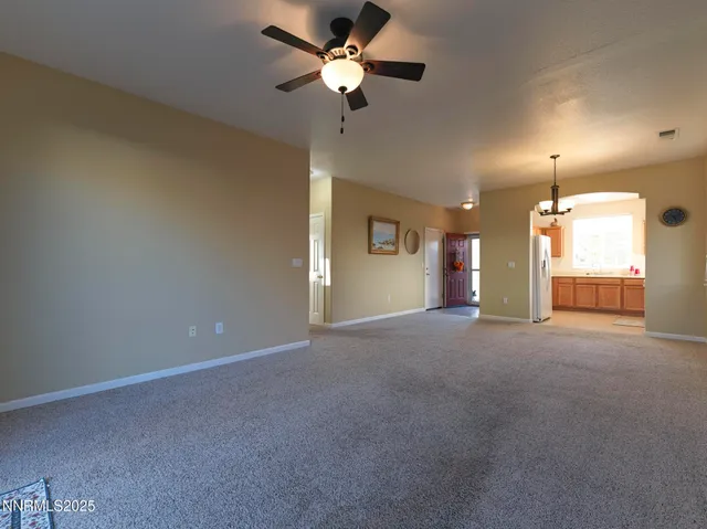 a view of an empty room and a ceiling fan