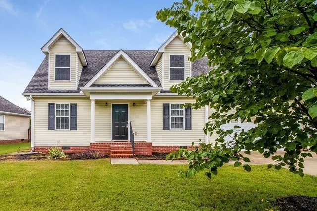 a front view of a house with a yard and garage