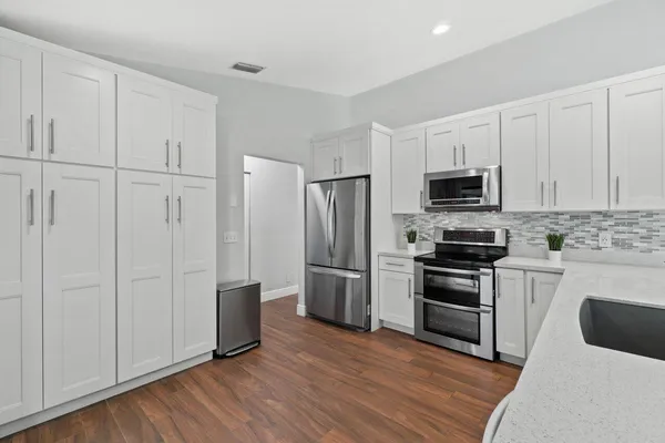 a kitchen with cabinets and stainless steel appliances