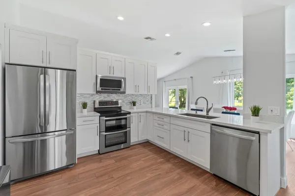 a kitchen with white cabinets and stainless steel appliances