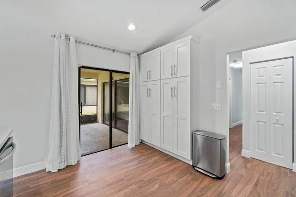 a view of empty room with wooden floor and window